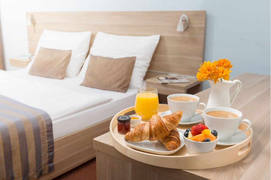 ліжко в готелі і сніданок на столі