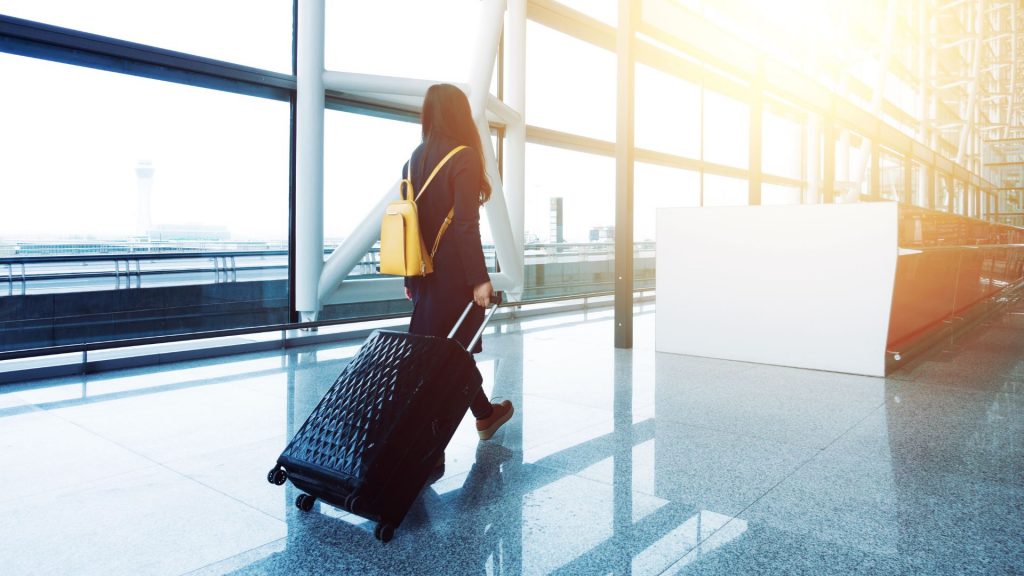 kobieta ciągnie walizkę na lotnisku