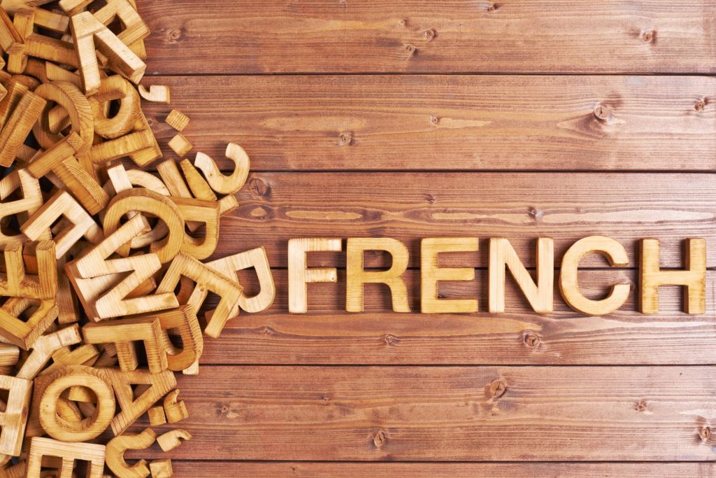 wooden background and with letters scattered the word french