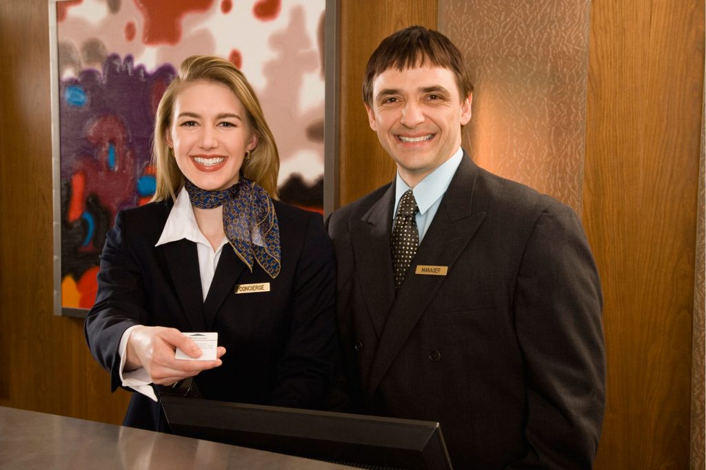 працівники готелю видають гостю картку в номер