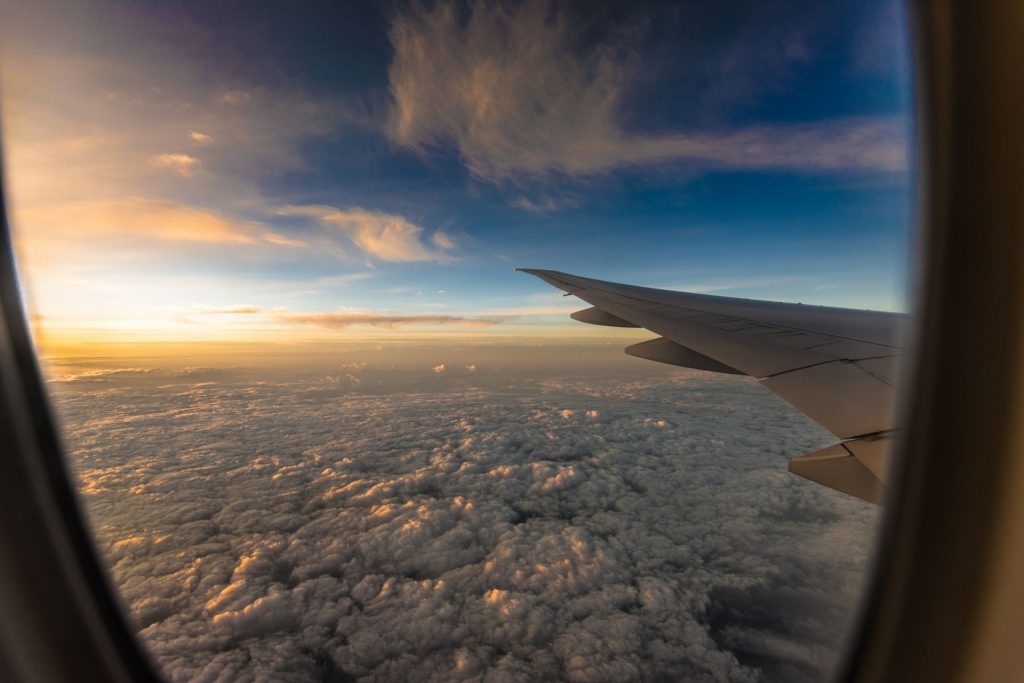 вид з вікна літака на хмари та захід сонця