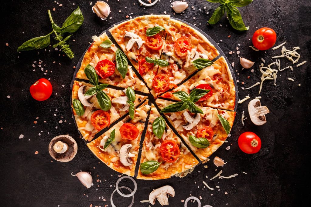 італійська піца лежить на чорному прилавку