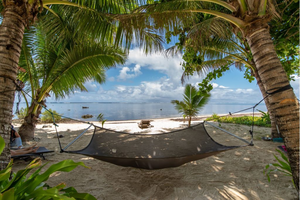 Hängematte zwischen Bäumen, Strand und Blick auf die Dose