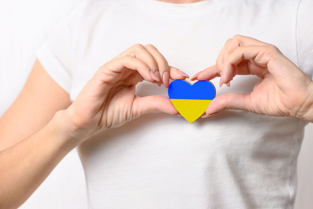 serce w kolorach flagi ukrainy jest trzymane w dłoniach przez osobę w białej koszulce