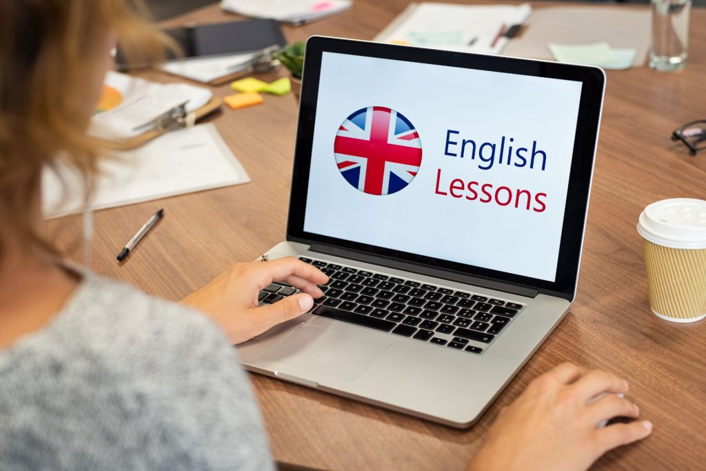 kobieta przy laptopie, z ekranem z napisem "English Lessons"