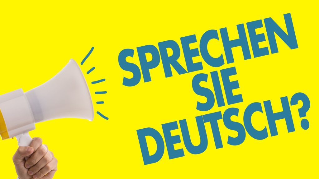 żółta tablica z megafonem i napisam: sprechen sie deutsch?