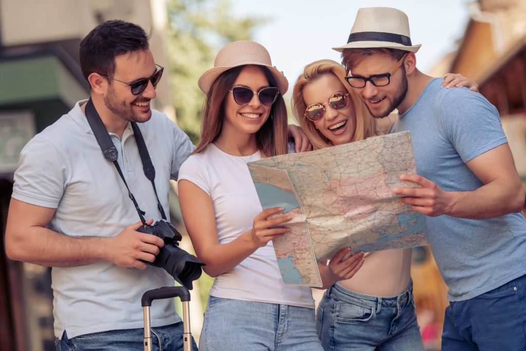 two men and two women on vacation with a map in their hands