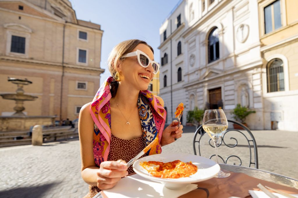 uśmiechnięta kobieta jedząca włoską lazanię