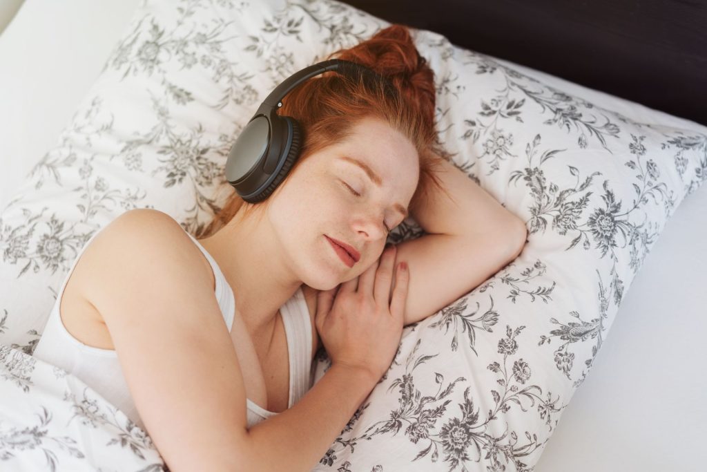 śpiąca kobieta w słuchawkach na uszach 
